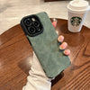 Green matte silicone iPhone case with soft-touch finish held over a table