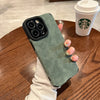 Green matte silicone iPhone case with soft-touch finish held over a table