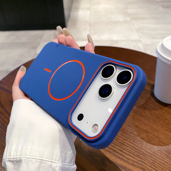 Blue matte iPhone case in hand showing the magnetic ring, slim profile, and camera-safe cutout.