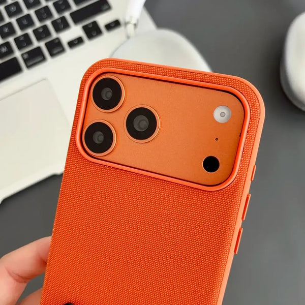 Close-up of orange woven iPhone case with raised camera protection and textured surface