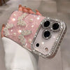 Pink translucent iPhone case with rhinestone butterflies and pearl accents, shown in hand.