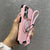 Pink armor iPhone case with lanyard and sliding camera cover shown in hand