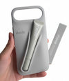 Hand holding a gray phone case with a cutout design, branded 'rhode', on a light surface.
