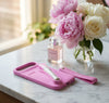Pink pet grooming tool held in a hand with 'rhode' branding on a white background