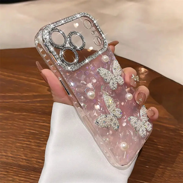 Clear and pink glitter iPhone case with rhinestone butterflies, pearl accents, and camera protection.