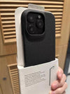 Black textured iPhone case displayed in packaging, highlighting the raised camera guard.