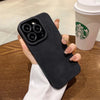 Black matte silicone iPhone case shown in hand with raised camera protection