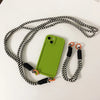 Green iPhone case with matching strap accessories arranged for a coordinated look.