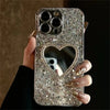 Silver glitter iPhone case with heart mirror cutout, held in hand