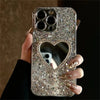 Silver glitter iPhone case with heart mirror cutout, held in hand
