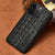 Close view of the crocodile-pattern iPhone case in a rich black finish with strong texture.