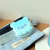Blue pastel bear stand case displayed resting on a soft pouch