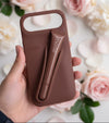 Trendora light gray matte silicone iPhone case with built-in lip gloss holder, raised camera bumper, and lanyard loop.